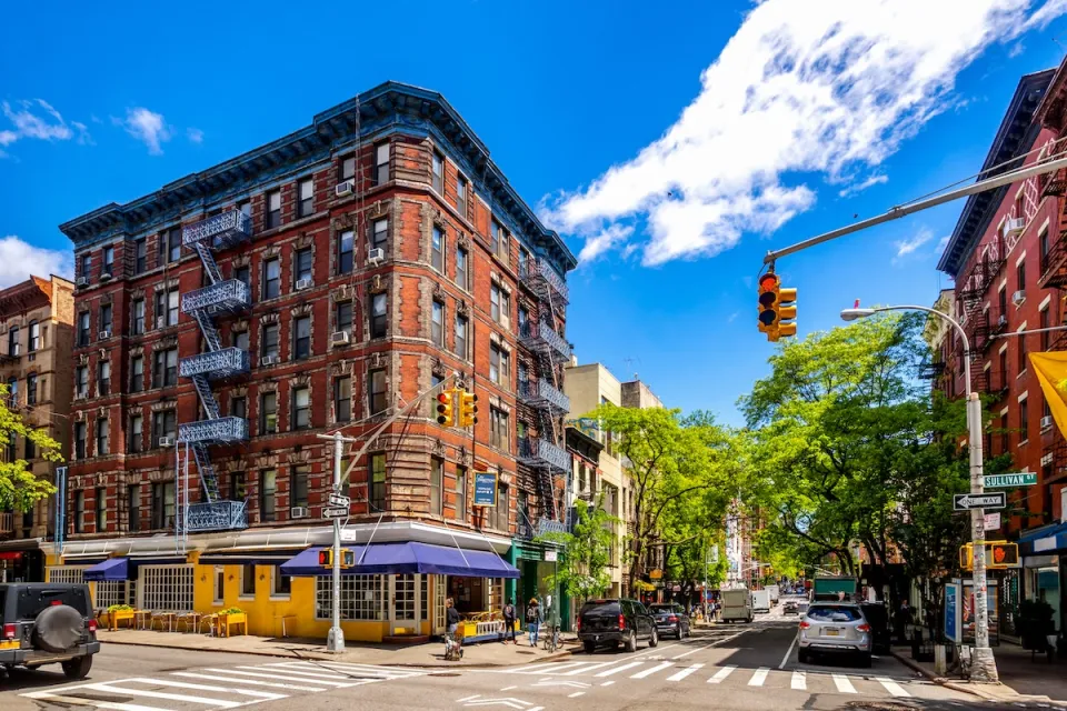 Mid-rise brick buildings with retail and restaurants on ground floor on sunny day in Soho, Manhattan, New York City.